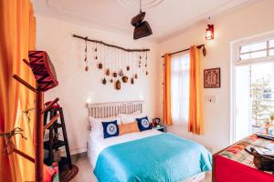 sypialnia z łóżkiem w kolorze niebieskim i pomarańczowym w obiekcie Parvatah w mieście Bir