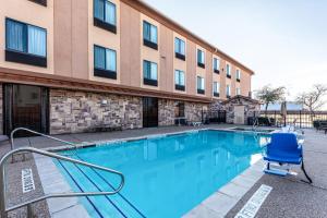 a swimming pool with a blue chair in front of a building at Red Lion Inn & Suites Mineral Wells in Mineral Wells