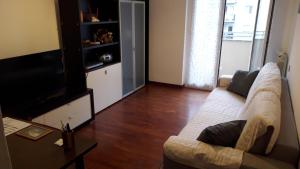 een woonkamer met een bank en een televisie bij Il Naviglio dietro l'angolo in Milaan
