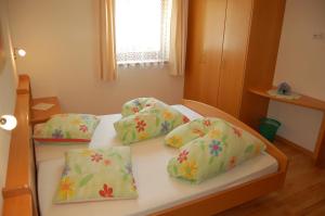 uma cama com quatro almofadas num quarto em Kaserhof em Bressanone
