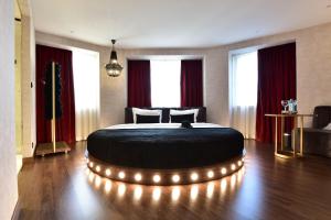 a bedroom with a large bed with lights around it at Maxime Hotel Lisbon in Lisbon