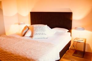 - une chambre avec un lit doté de draps et d'oreillers blancs dans l'établissement Locanda della Scala, à San Quirico dʼOrcia