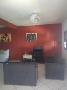 a living room with a red wall at Casa Majorlandia in Majorlândia