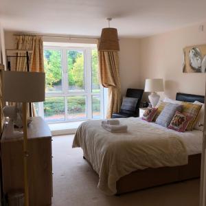 a bedroom with a bed and a large window at Sky Night Serviced Apartments in Cardiff
