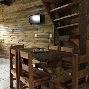 ein Esszimmer mit einem Tisch und Stühlen sowie einem TV in der Unterkunft Cabanas MFK in Machadinho