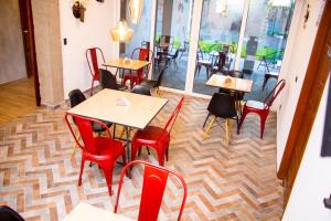 an empty restaurant with tables and red chairs at Hotel Citlalli in San Salvador
