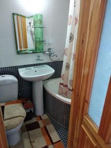 a bathroom with a sink and a toilet and a mirror at Hotel Sartepo in Samarkand