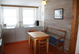 eine Küche mit einem Tisch und Stühlen sowie einer Holzwand in der Unterkunft Schönhaar Schwenden 2 in Argenbühl