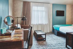 ein Hotelzimmer mit einem Bett und einem Schreibtisch mit Spiegel in der Unterkunft The Garrison in Fort William