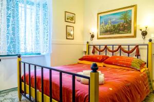 a bedroom with a bed with a red comforter at Villa Scozilia in Piedimonte Etneo