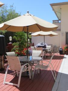 Colton Inn في مونتيري: طاولة وكراسي مع مظلة على الفناء