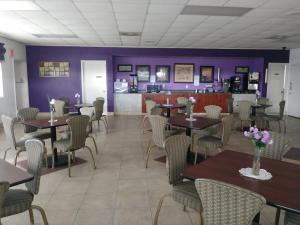 comedor con mesas, sillas y paredes púrpuras en Knights Inn San Antonio near Frost Bank Center, en San Antonio