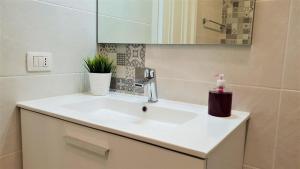 a bathroom with a white sink and a mirror at Home Sweet Home in Arona