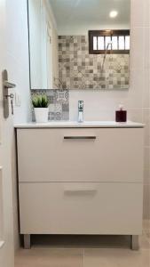 a white bathroom with a sink and a mirror at Home Sweet Home in Arona