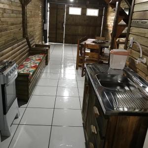 uma cozinha com um lavatório e um sofá num quarto em Cabanas MFK em Machadinho