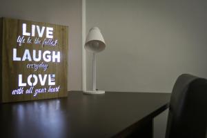 a desk with a lamp and a sign on it at Alex Lodge in Zrenjanin