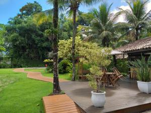 una terraza de madera con palmeras y una mesa de picnic en Pousada das Maritacas, en Ilhabela