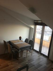a dining room with a table and chairs and a window at Apartman MIG in Solin