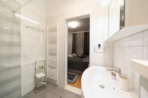 a white bathroom with a sink and a mirror at Apartment Garden Terrace in Zadar +65 photos