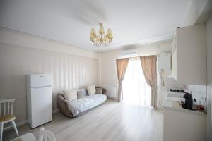a small white room with a couch and a window at Complex Bavaro in Mamaia Sat/Năvodari