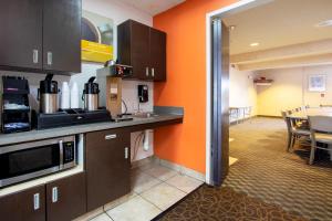 a kitchen with orange walls and a dining room at El Paso Inn in Ysleta