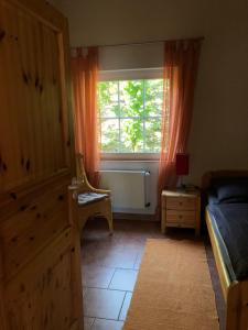een slaapkamer met een bed, een raam en een stoel bij Ferienwohnung Karl in Kesten