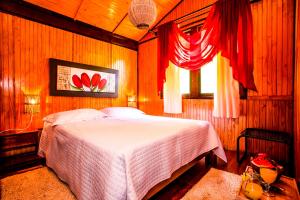 um quarto com uma cama em um quarto com janela em Hotel Fazenda Floresta Negra em Monte Verde mais 120 fotografias