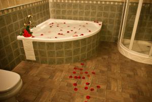 ein Badezimmer mit einer Badewanne mit roten Rosen auf dem Boden in der Unterkunft Casas Rurales Cazorla-Alcón in Pozo Alcón