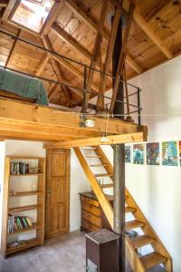 a loft bed in a room with wooden ceilings at Piges in Milína