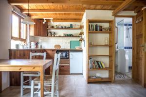 a kitchen with a wooden table and a dining room at Piges in Milína