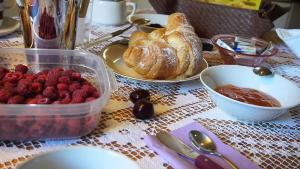 a table with a tray of berries and croissants and bread at B&B Castellani in Fanna