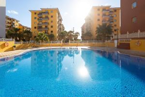una gran piscina azul con edificios en el fondo en Home2Book Charming Caletillas Pool, en Candelaria