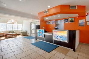 una sala de espera con paredes de color naranja y TV en Motel 6-El Paso, TX - Southeast, en El Paso