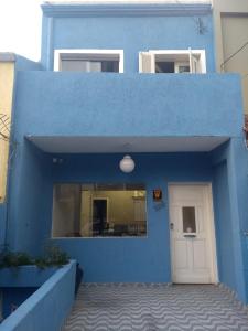 um edifício azul com uma porta branca em Hostel Santana - Metrô Santana em São Paulo