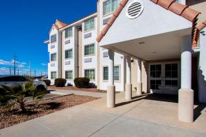 a white building with a car parked in front of it at El Paso Inn in Ysleta