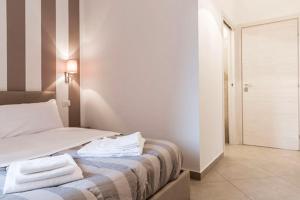 a bedroom with a bed with towels on it at MINERVA GUEST HOUSE in Pavia