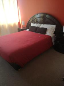 Un dormitorio con una gran cama roja con almohadas blancas en Teatinos 690, en Santiago