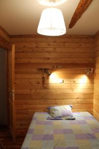 a bedroom with a bed with a wooden wall at appartement style chalet centre Barcelonnette in Barcelonnette