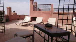 um grupo de cadeiras e uma mesa no telhado em Appartment Jnane Atlas em Marrakech