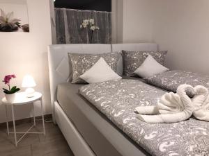 - un canapé gris avec une serviette dans la chambre dans l'établissement Haus am See, à Füssen