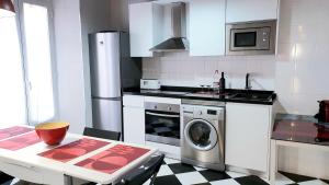 kuchnia ze stołem i pralką w obiekcie Gran Apartamento Centro Histórico w Maladze