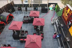 a group of red tables and chairs on a sidewalk at Hotel Stellar in Vadodara