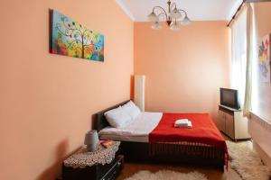 a small bedroom with a bed with a red blanket at Smart Lwow House in Lviv