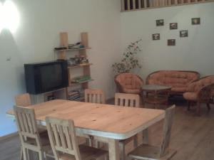 salon z drewnianym stołem i telewizorem w obiekcie Pod Orzechem w mieście Sanok