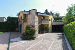 een geel huis met een garage en een oprit bij Rosa Tea in Monteforte dʼAlpone