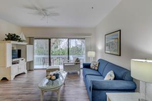 a living room with a blue couch and a table at Ocean Breeze in Hilton Head Island