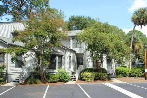a white house with trees and a parking lot at Ocean Breeze 23 in Hilton Head Island
