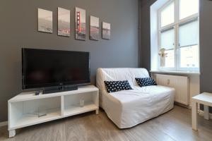 Una sala de estar con un televisor de pantalla plana y un sofá. en Best Location Old Town, en Poznan