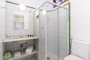 a bathroom with a shower and a sink and a toilet at Pousada Peixes do Mar in Ubatuba