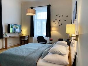 um quarto com uma cama, uma secretária e uma televisão em Marienbad Apartment em Mariánské Lázně